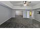 Expansive carpeted room featuring a tray ceiling with fan, plus views into an additional sitting room at 5025 Wicklow Dr, Gastonia, NC 28054