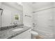Bathroom with granite counter, bath and shower combo, with neutral flooring at 505 E Robinson St, Dallas, NC 28034