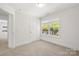 Bright bedroom with a large window providing an outside view and neutral carpet at 505 E Robinson St, Dallas, NC 28034