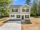 Charming two-story home features a gray siding, black shutters, and a concrete driveway leading to the front door at 505 E Robinson St, Dallas, NC 28034