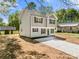 Charming two-story home features a gray siding, black shutters, and a concrete driveway leading to the front door at 505 E Robinson St, Dallas, NC 28034