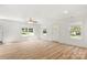 Bright living room features wood-look flooring, neutral walls, a ceiling fan, and ample natural light from the windows at 505 E Robinson St, Dallas, NC 28034