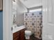 Bright bathroom features a large vanity, toilet, and shower with patterned shower curtain at 5102 Candleglow Ct, Indian Trail, NC 28079
