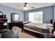 This bedroom includes a ceiling fan, a dark dresser and mirror set and natural light at 5102 Candleglow Ct, Indian Trail, NC 28079