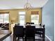 Bright dining room features modern light fixture, large table, and natural light from windows at 5102 Candleglow Ct, Indian Trail, NC 28079