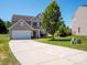 Traditional two-story home with a long driveway, attached garage, and well-manicured front lawn at 5102 Candleglow Ct, Indian Trail, NC 28079