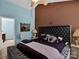 This main bedroom boasts stylish decor, a tufted headboard, a sitting bench, and a neutral toned ceiling fan at 5102 Candleglow Ct, Indian Trail, NC 28079