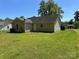 Rear exterior of home surrounded by green grass and mature trees at 6239 Burmith Ave, Charlotte, NC 28269