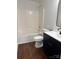 Modern bathroom features a vanity with dark cabinets and a shower-tub combo at 6239 Burmith Ave, Charlotte, NC 28269