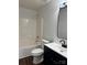 Modern bathroom features a vanity with dark cabinets and a shower-tub combo at 6239 Burmith Ave, Charlotte, NC 28269
