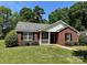 Charming red brick home with black shutters, a welcoming porch, and a well-manicured lawn at 6239 Burmith Ave, Charlotte, NC 28269