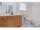 Bathroom with an oak vanity, a glass block window and tile flooring at 6549 Wesbrook Dr, Charlotte, NC 28214