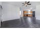 Open-concept living room with dark vinyl flooring leading into a kitchen with wooden cabinets and modern appliances at 6549 Wesbrook Dr, Charlotte, NC 28214