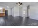Spacious living room featuring dark vinyl floors, neutral walls, ceiling fan, and ample natural light at 6549 Wesbrook Dr, Charlotte, NC 28214