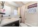 Bathroom with subway tile shower, updated vanity, and window at 665 Melbourne Ct, Charlotte, NC 28209