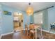 Dining area featuring hardwood floors, light blue walls, a decorative light fixture, and kitchen access at 665 Melbourne Ct, Charlotte, NC 28209