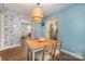 Dining area showcasing hardwood floors, designer wallpaper, and a view into the bright, inviting living room at 665 Melbourne Ct, Charlotte, NC 28209