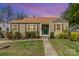Charming single-story home featuring a cozy front porch, well-maintained landscaping, and a lush green lawn at 665 Melbourne Ct, Charlotte, NC 28209