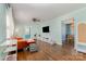 Bright living room with hardwood floors, large windows, a television, and a view into the dining area at 665 Melbourne Ct, Charlotte, NC 28209