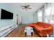 Inviting living room with hardwood floors, a modern sofa, a wall-mounted TV, and ample natural light at 665 Melbourne Ct, Charlotte, NC 28209