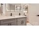 Modern bathroom featuring double sinks, gray cabinets, and an illuminated mirror at 700 Cooper Dr, Charlotte, NC 28210