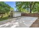 Exterior view with a driveway leading up to the house, with a yard and fence nearby, and some trees overhead at 700 Cooper Dr, Charlotte, NC 28210