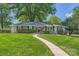 Charming single-story home boasts a lush green lawn and inviting walkway at 700 Cooper Dr, Charlotte, NC 28210