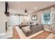 Comfortable living room featuring a gray sofa, hardwood floors, and a window overlooking the backyard at 700 Cooper Dr, Charlotte, NC 28210