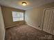 Bedroom with large window, neutral colored carpet, and closet at 7154 Woodcock Trl, Stanley, NC 28164