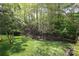 Lush backyard featuring mature trees, a wooden fence, and a well-maintained lawn at 7515 Shadowstone Dr, Charlotte, NC 28270