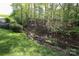 Grassy backyard with a wooden fence and natural features, perfect for outdoor enjoyment at 7515 Shadowstone Dr, Charlotte, NC 28270