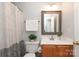 Bathroom with a shower, a toilet, and a vanity with a stylish framed mirror at 7515 Shadowstone Dr, Charlotte, NC 28270