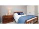 Bedroom featuring wood furniture, a comfortable bed with blue accents, and neutral walls at 7515 Shadowstone Dr, Charlotte, NC 28270