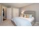 Comfortable bedroom with soft, neutral colors, carpet, and a decorative upholstered headboard at 7515 Shadowstone Dr, Charlotte, NC 28270