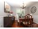Elegant dining room with dark wood table, soft chairs, buffet and a decorative wall clock at 7515 Shadowstone Dr, Charlotte, NC 28270