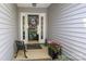 Welcoming front porch with a decorative wreath, flowers, and a charming bench at 7515 Shadowstone Dr, Charlotte, NC 28270
