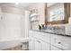 A well-lit bathroom with a bathtub and shower, and vanity with granite countertops at 7910 Camden Hollow Rd, Huntersville, NC 28078