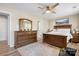 This bedroom features wood flooring, a ceiling fan, and a matching dresser with a large mirror at 7910 Camden Hollow Rd, Huntersville, NC 28078