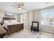 This bedroom features wood flooring, bright windows with white curtains, and a comfortable leather chair at 7910 Camden Hollow Rd, Huntersville, NC 28078