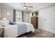 A bright bedroom featuring a cozy bed, wood flooring, and a view of the backyard at 7910 Camden Hollow Rd, Huntersville, NC 28078