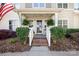Inviting front porch features lovely landscaping, brick stairs, decorative plants, and string lights for relaxed outdoor living at 7910 Camden Hollow Rd, Huntersville, NC 28078