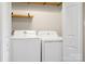 A well-lit laundry room featuring a new washer and dryer, and shelving at 7910 Camden Hollow Rd, Huntersville, NC 28078