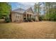 Wide backyard featuring a covered porch, black metal fence, and mature trees at 7982 Buena Vista Dr, Denver, NC 28037