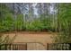 A tiered backyard with lush green lawn and a border of mature trees at 7982 Buena Vista Dr, Denver, NC 28037