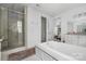 Bright bathroom featuring a large soaking tub, glass shower and vanity with ample cabinet space at 7982 Buena Vista Dr, Denver, NC 28037