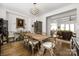 Charming dining room featuring a rustic wooden table, chandelier, and seamless transition to the living room at 7982 Buena Vista Dr, Denver, NC 28037