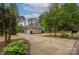 Long driveway leads to a brick house with a three-car garage surrounded by trees at 7982 Buena Vista Dr, Denver, NC 28037