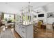 Open-concept kitchen features a large island, granite countertops, and modern lighting, seamlessly flowing into the living area at 7982 Buena Vista Dr, Denver, NC 28037