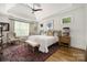 Serene bedroom with a tray ceiling, neutral tones, hardwood floors, and large windows that provide ample natural light at 7982 Buena Vista Dr, Denver, NC 28037