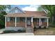 Charming single-story home featuring a cozy front porch with wood railings and stairs at 925 14Th St, Lancaster, SC 29720